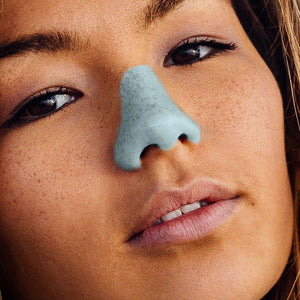 Nöz Nözscreen neon color blue sunscreen on brunette womans nose